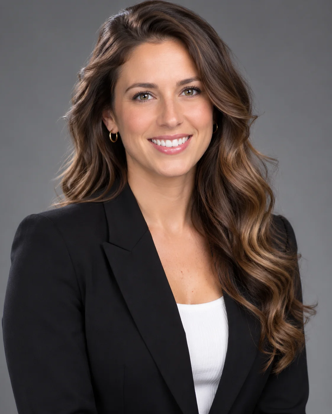 Professional corporate headshot of a smiling woman in a blazer, clean neutral gray backdrop, soft key light, sharp eyes, LinkedIn-quality studio portrait. AI Headshot